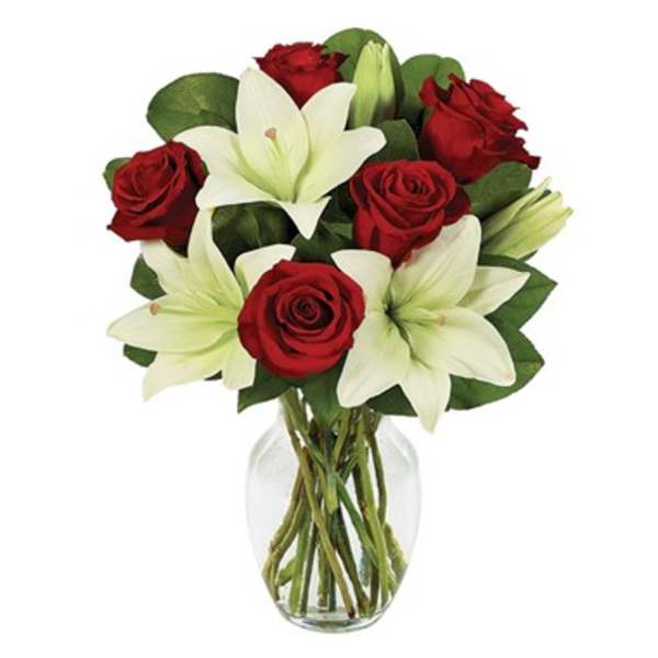 Red roses and white lilies in a clear glass vase