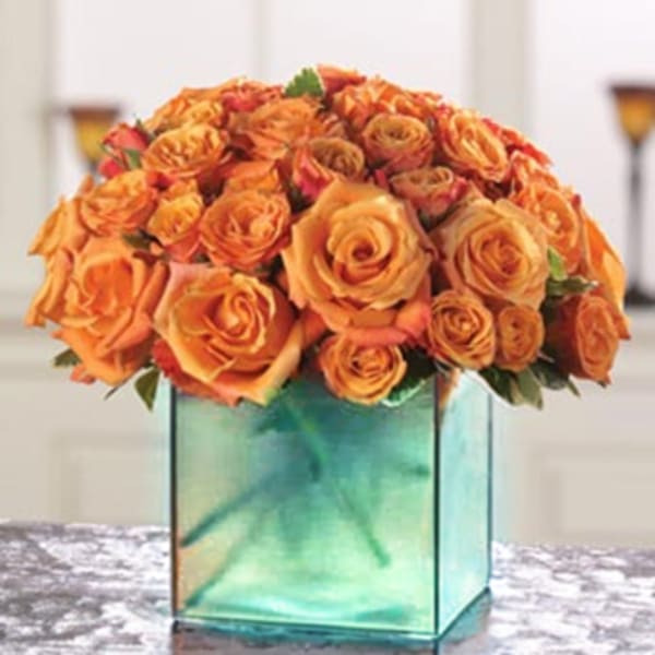 Orange rose bouquet in a square glass vase
