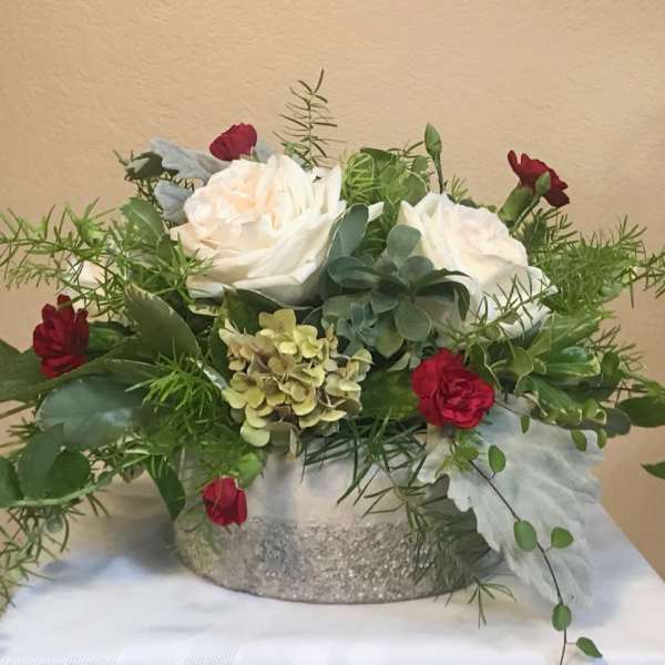 White roses and red carnations in a glittery silver container