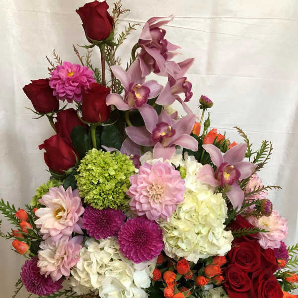 Mixed bouquet with red roses, pink orchids, and hydrangeas in a vase