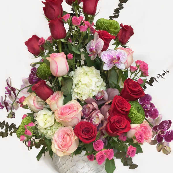 Mixed bouquet of red and pink roses in a clear glass vase