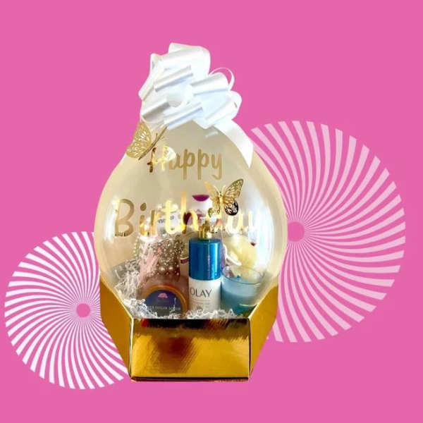 Birthday gift basket with a clear balloon topper and white bow