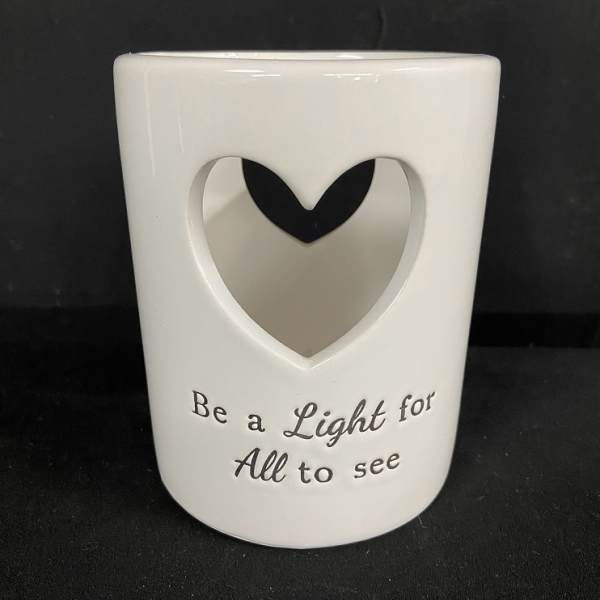 White ceramic candle holder with a heart cutout and printed text
