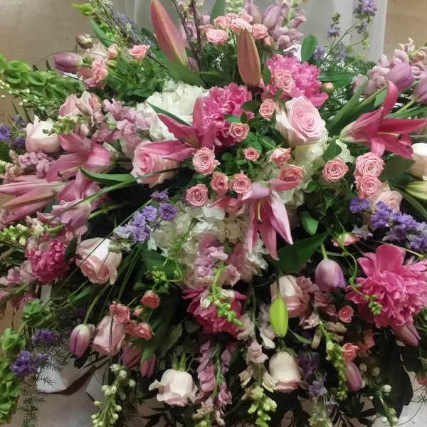 Large pink and white floral arrangement with lilies, roses, and mixed blooms