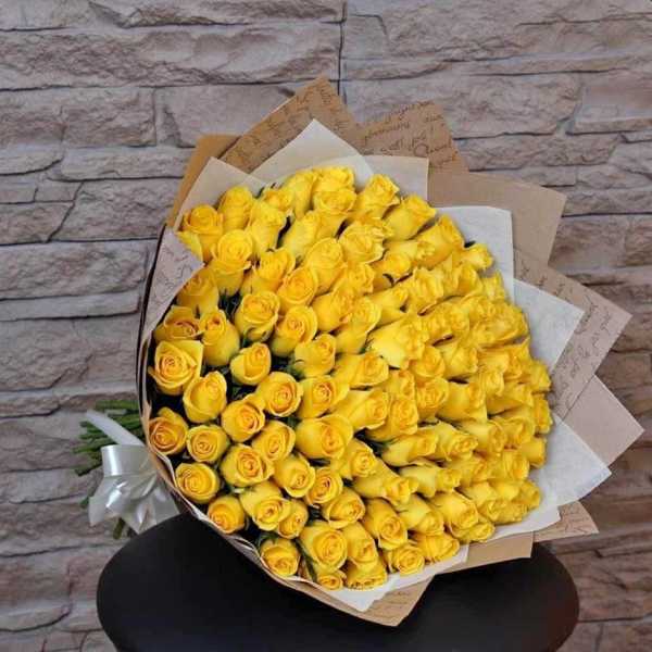 Large bouquet of yellow roses wrapped in brown paper
