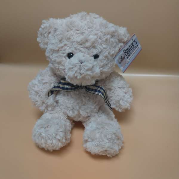 White plush teddy bear with a plaid ribbon around its neck