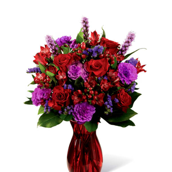 Red and purple mixed bouquet in a red glass vase
