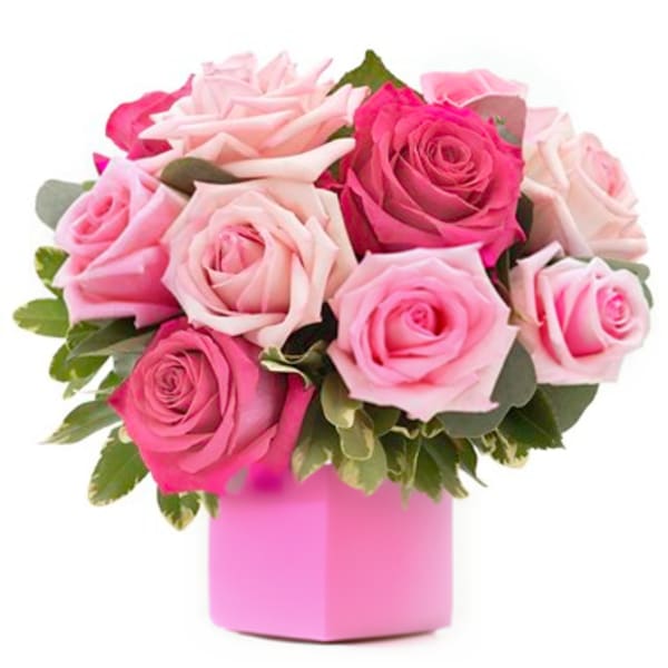 Pink and blush roses arranged in a pink box vase