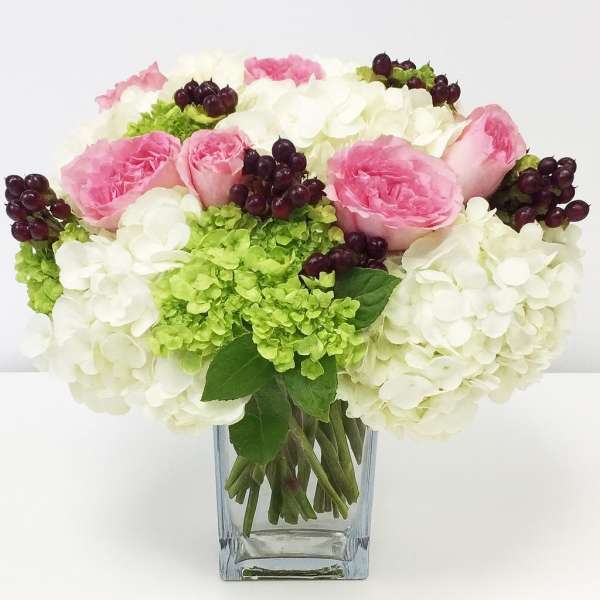Pink roses and white hydrangeas in a clear glass vase