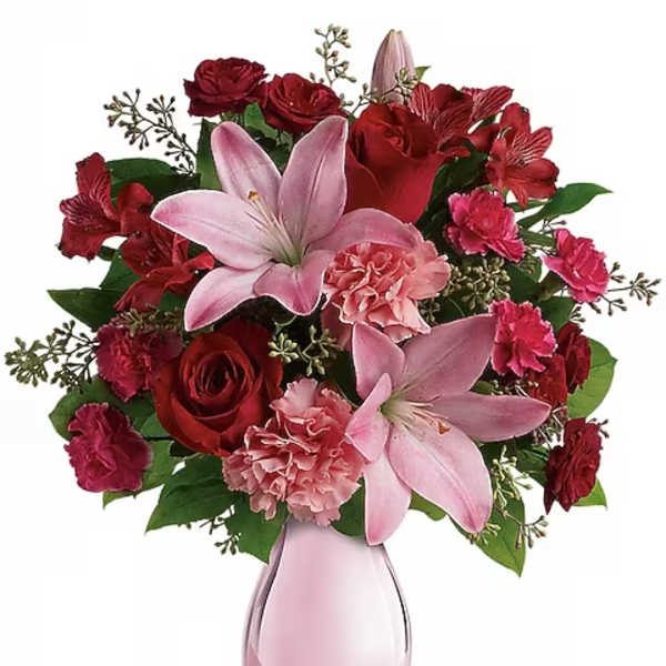Pink lilies and red roses in a pink glass vase
