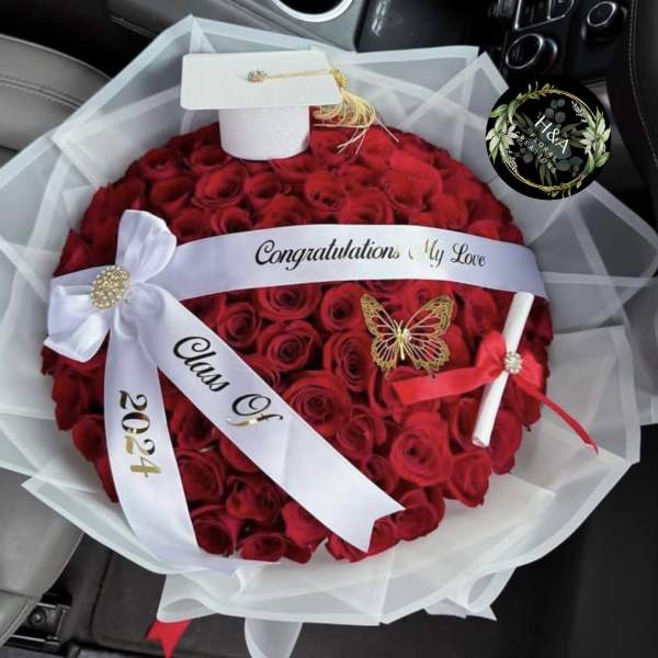 Round bouquet of red roses with white ribbon and decorative wrap