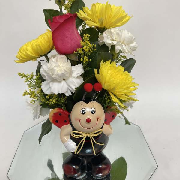 Bouquet with yellow and white flowers in a ladybug figurine vase