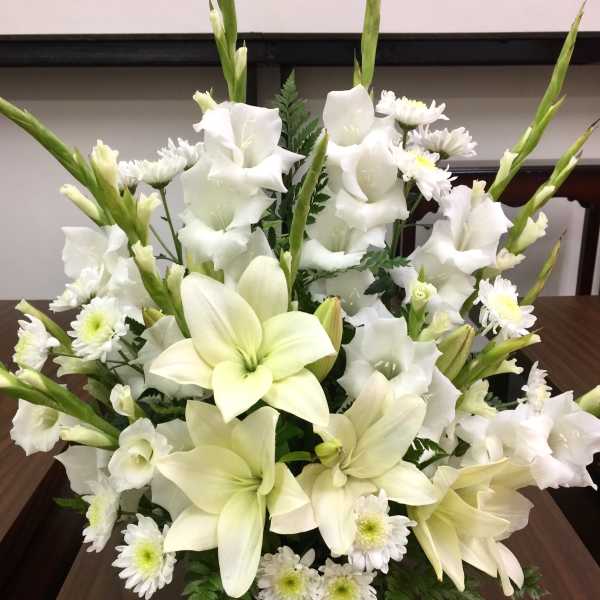 White lilies and daisies arranged in a low bouquet