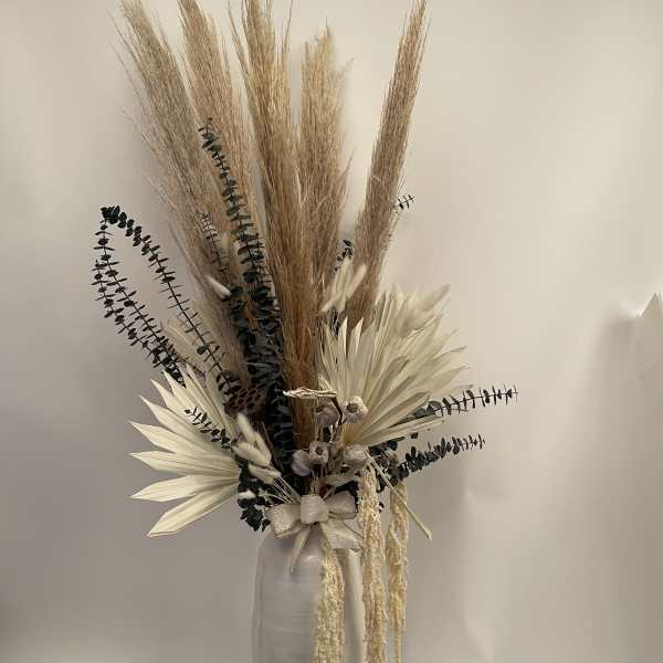 Tall dried floral arrangement in a white vase with pampas grass and cream accents