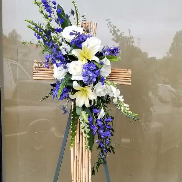 Blue and white floral cross on a bamboo stand