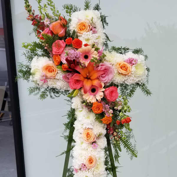 Cross-shaped floral standing spray with white blooms and peach, pink, and orange flowers