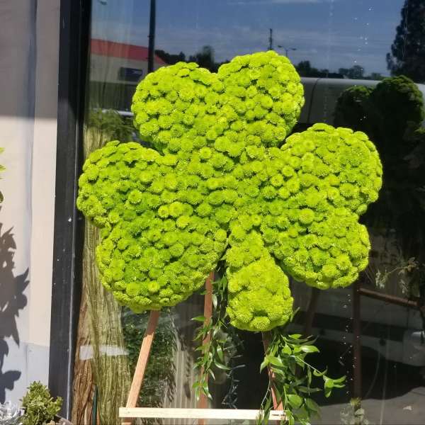 Bright green floral arrangement shaped like a four-leaf clover