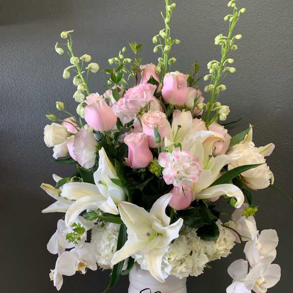 Pink and white floral arrangement in a white vase