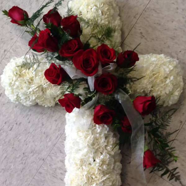 Cross-shaped floral arrangement with red roses and white blooms
