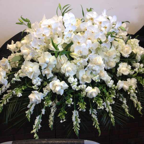 Large white floral arrangement with orchids and roses