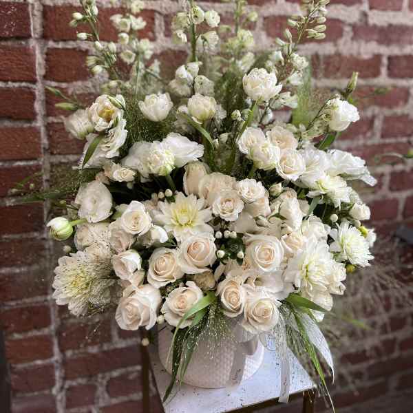 White rose and chrysanthemum arrangement in a pale vase