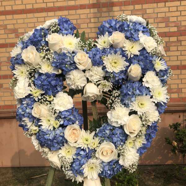 Heart-shaped floral wreath with blue hydrangeas, white roses, and white daisies