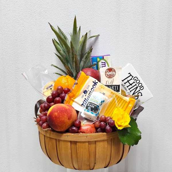 Fruit and cheese gift basket with grapes, peach, pineapple, and packaged snacks