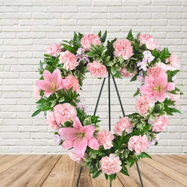 Pink floral heart wreath on a black stand