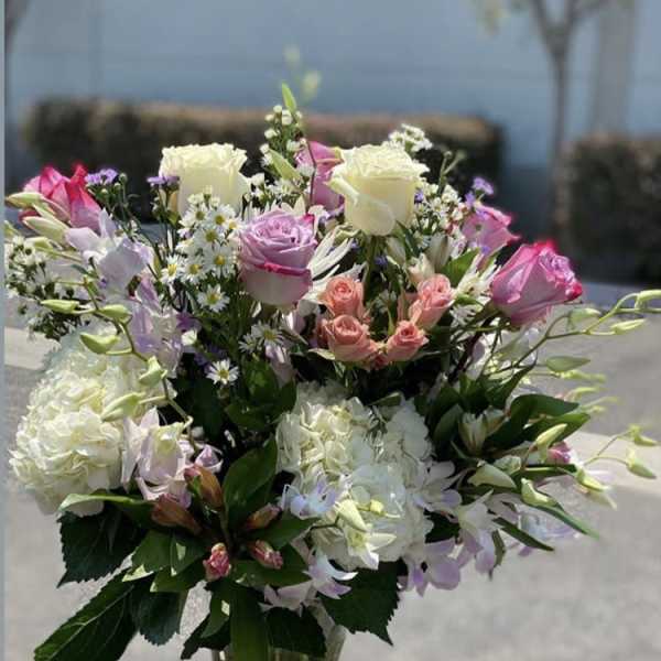 Mixed bouquet of pink and white roses in a clear glass vase