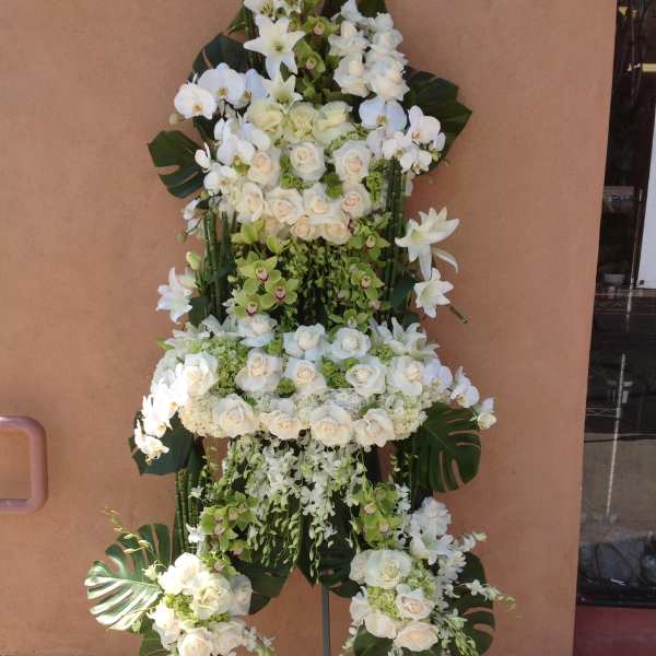 Tall white floral standing spray with roses and orchids