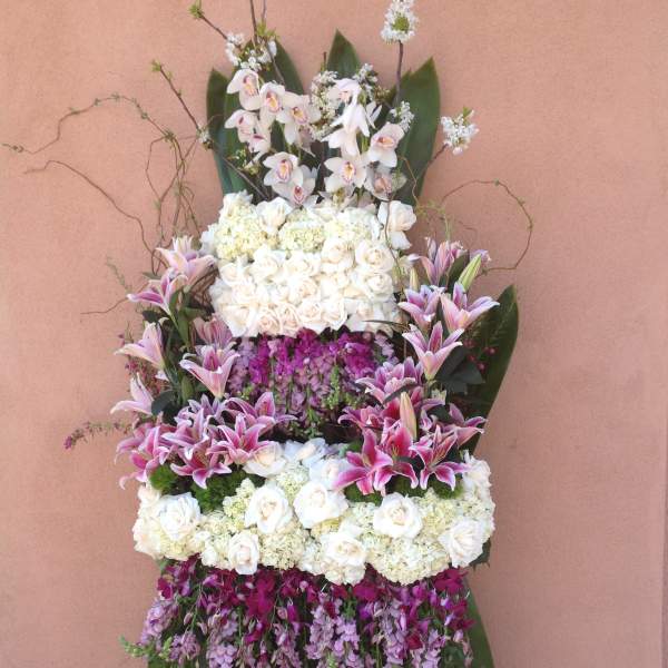 Tall standing floral spray with white roses, orchids, and pink lilies