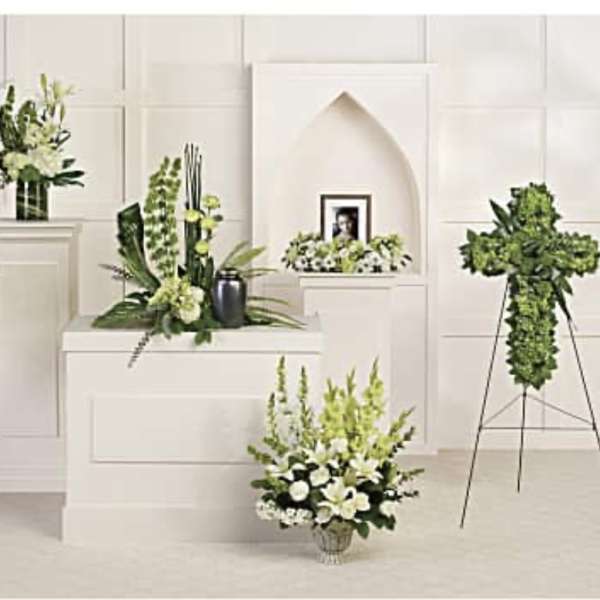 White and green funeral floral arrangements on stands and pedestals