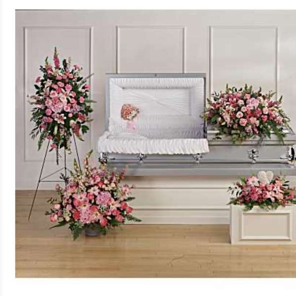 Pink floral funeral casket spray with matching standing arrangements and wreaths