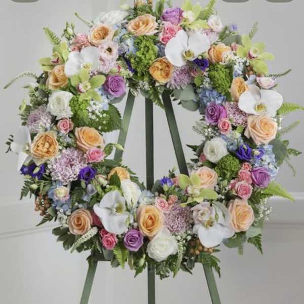 Pastel floral wreath on a stand with roses and white orchids