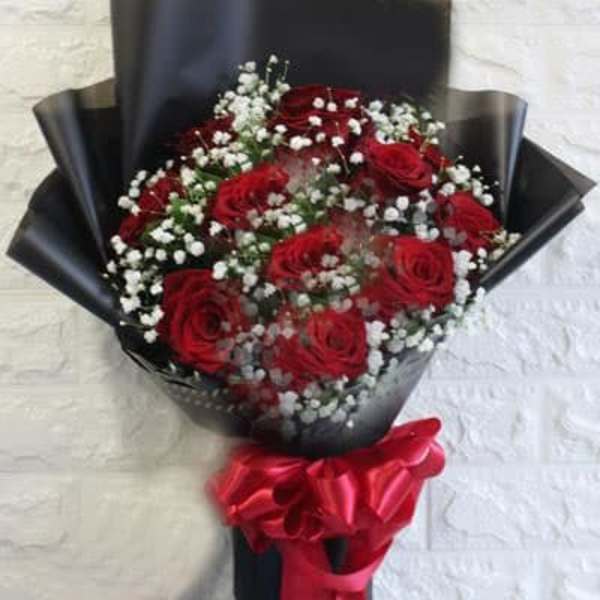 Bouquet of red roses with white baby's breath wrapped in black paper