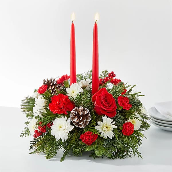 Holiday centerpiece with red candles, roses, carnations, and pinecones