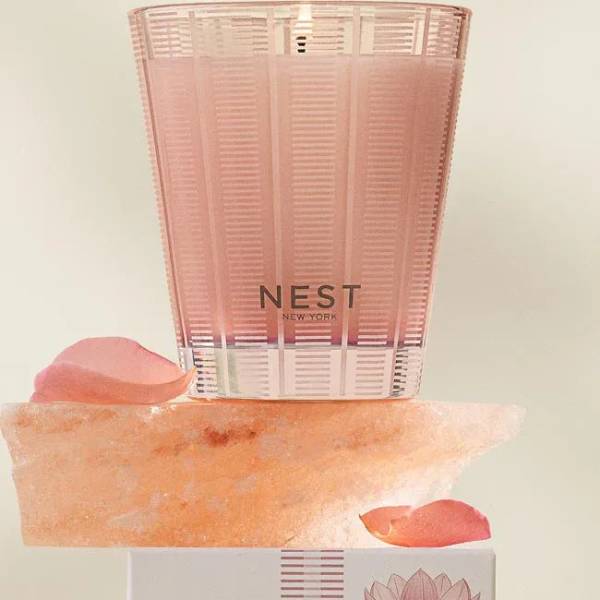 Pink Nest New York candle in a translucent holder with rose petals