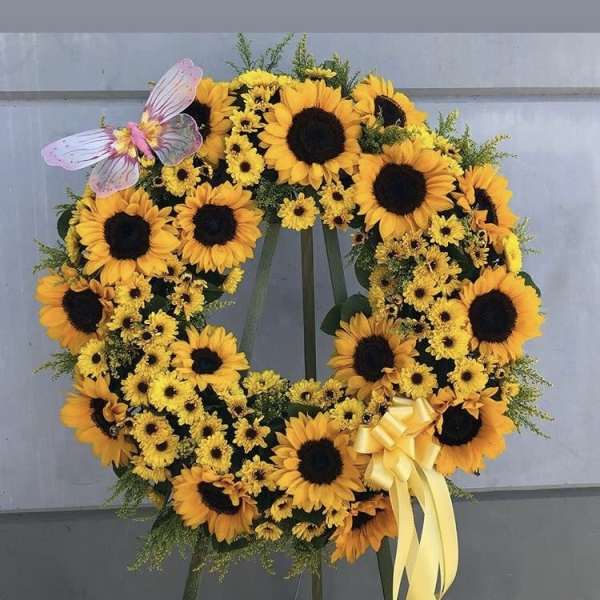 Sunflower wreath with a yellow ribbon and butterfly accent
