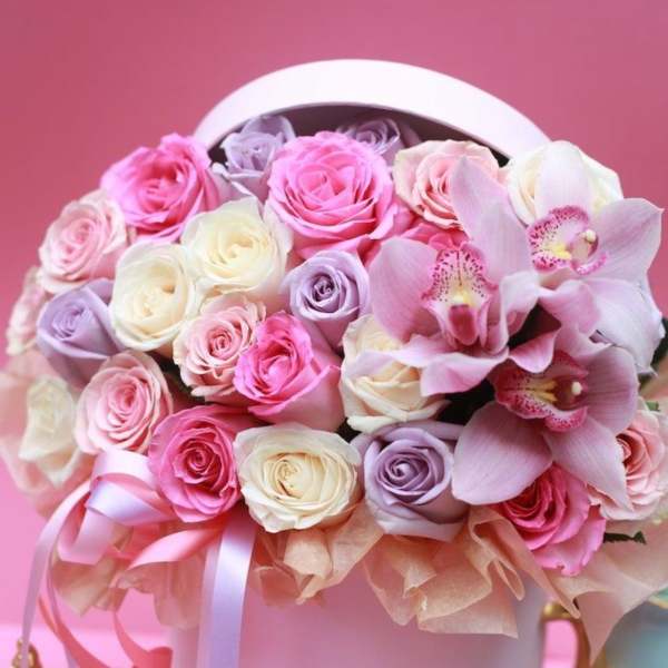 Pink and white roses with orchids in a round hatbox
