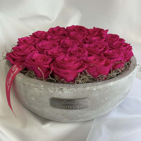 Hot pink roses arranged in a round gray container