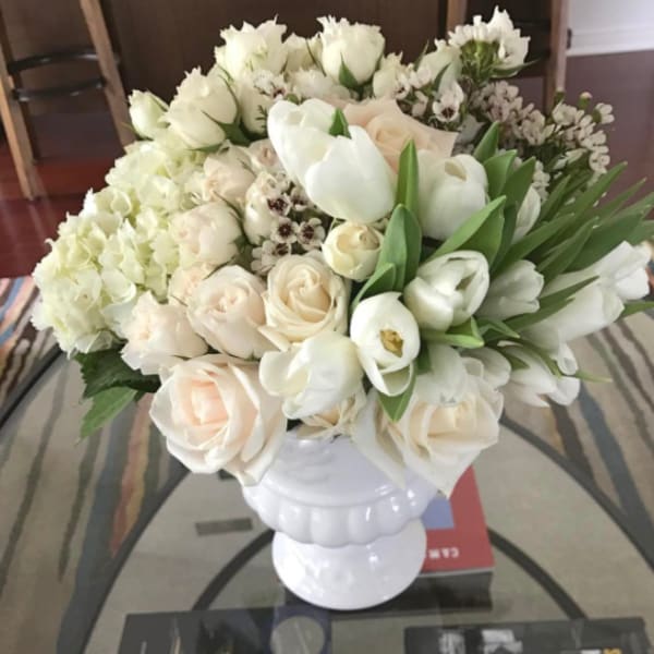 White floral arrangement in a white pedestal vase