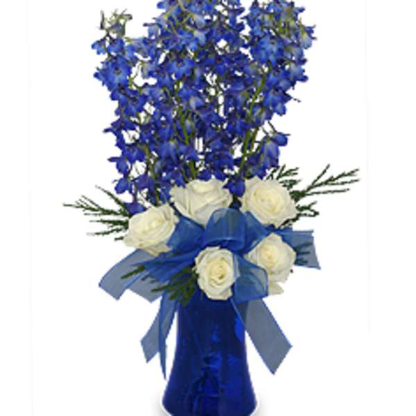 Blue delphinium and white roses in a blue vase with ribbon