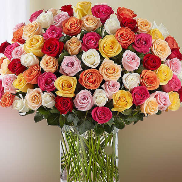 Large bouquet of multicolored roses in a clear glass vase
