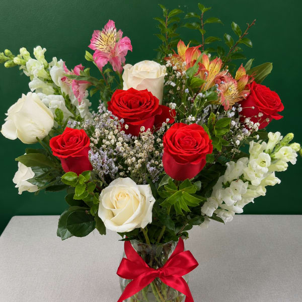 Bouquet of red and white roses with pink alstroemeria in a glass vase
