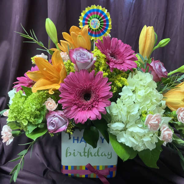 Colorful birthday flower arrangement in a box with gerberas, lilies, roses, and hydrangeas