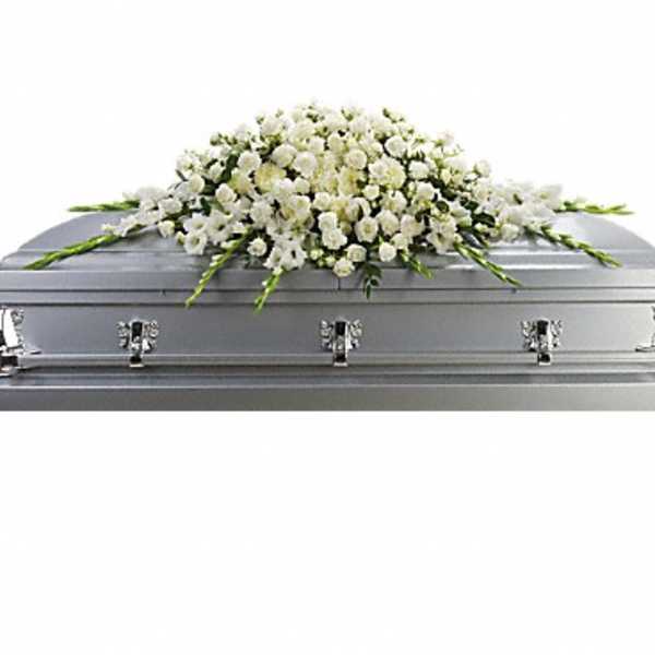 White floral casket spray on a silver casket