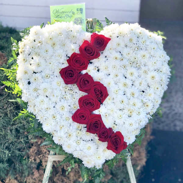Heart-shaped floral tribute with white daisies and red roses