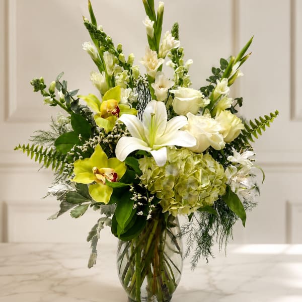 White and green floral arrangement in a glass vase