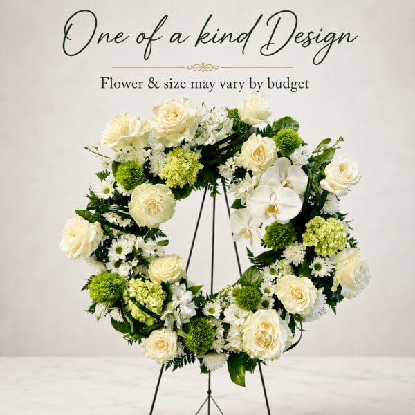 Cream rose and orchid wreath on a black stand