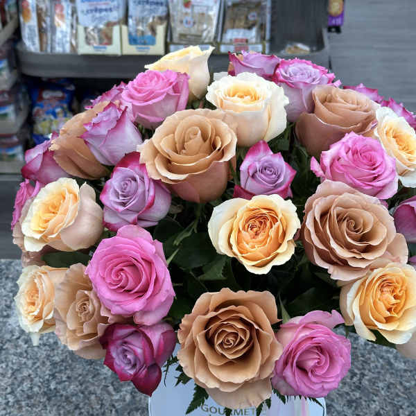 Bouquet of pink, peach, and lavender roses in a white hat box